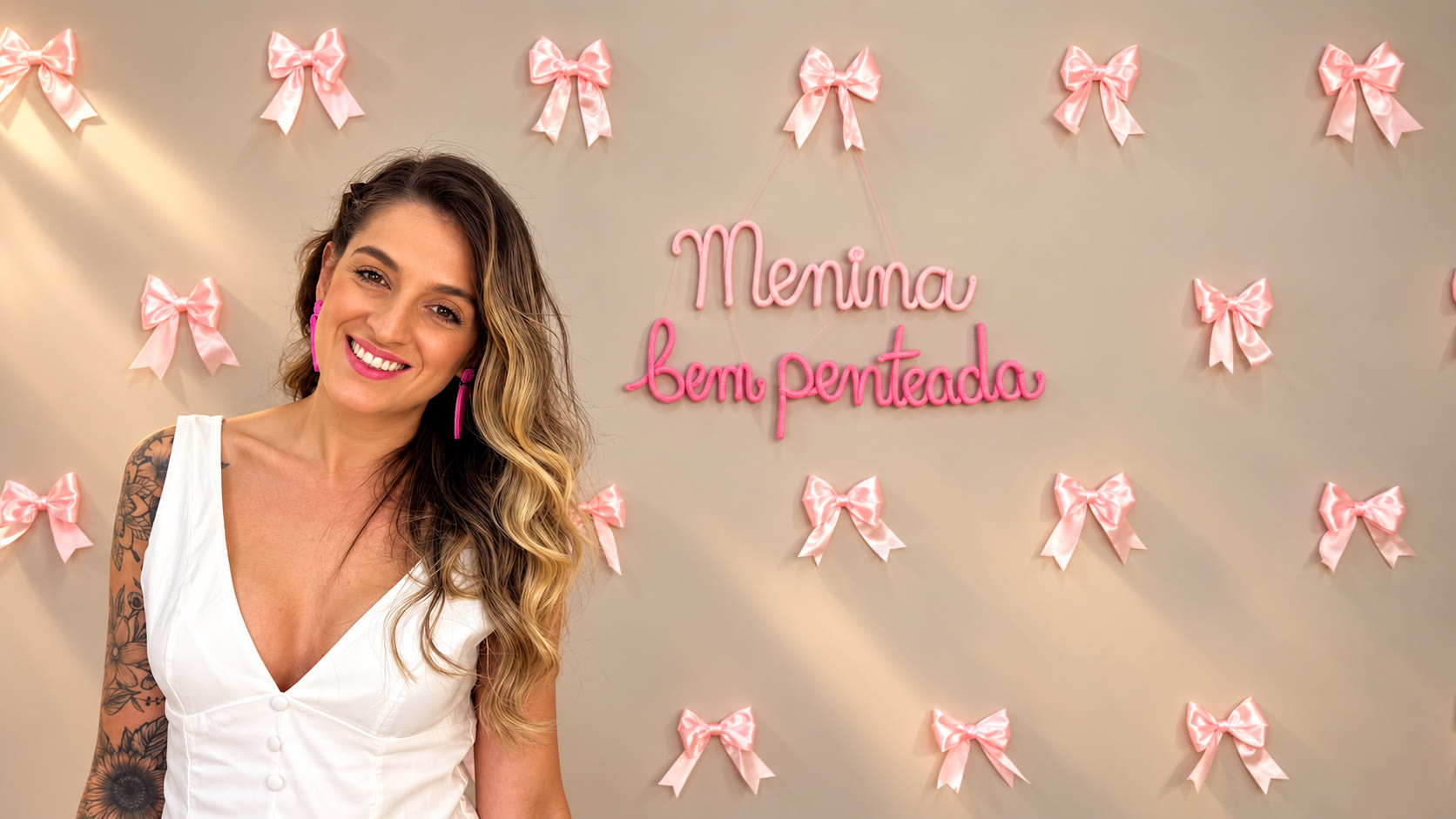 Manu, criadora do Menina Bem Penteada, em frente ao letreiro da marca